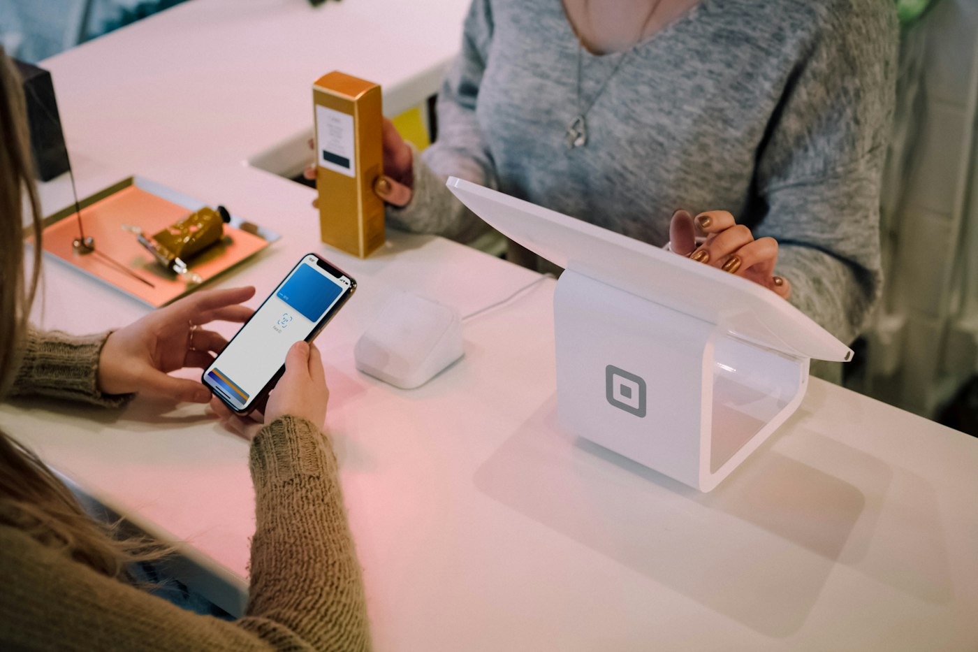 Customer at the counter completing a purchase with a smartphone